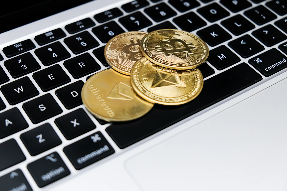 Gold-colored crypto coins resting on a laptop keyboard